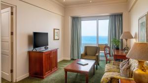 a hotel room with a television and a living room at The Edward in Durban