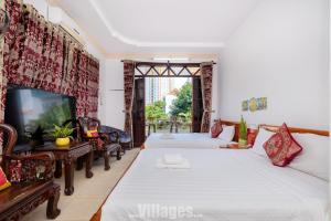 a hotel room with two beds and a tv at Villa Bãi Sau Vũng Tàu Free SUB - Xe Máy in Vung Tau