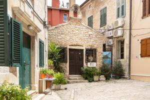 an old stone building with a door in an alley at Gloria apartment Rovinj - Heart of Old town - Steps from Sea in Rovinj