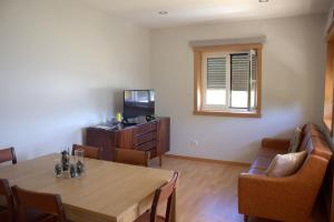 a dining room with a table and chairs and a television at Casa do Regueirinho in Vila Nova de Cerveira