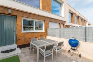 Un patio con parrilla y mesa y sillas. en Martina, en Puerto Marino