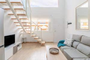 Una sala de estar con un sofá y una escalera. en Martina, en Puerto Marino