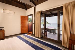 a bedroom with a bed and a view of the ocean at The Ark Comforts in Palolem