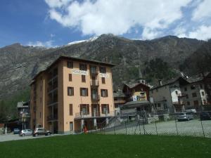 a building in a town with mountains in the background at Residence Hotel Moderno in Gaby