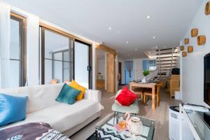 - un salon avec un canapé blanc et des oreillers colorés dans l'établissement Minimal House Maximum Happiness, à Thung Maha Mek