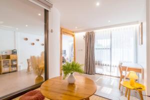 un salon avec une table et une grande fenêtre dans l'établissement Minimal House Maximum Happiness, à Thung Maha Mek