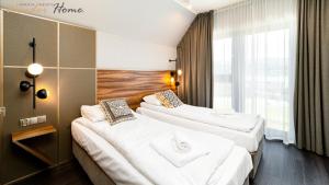 ソスノフカにあるWonder Hill - klimatyzowane apartamenty z bajkowym widokiem na góry i zalewのベッドが2つと窓があるホテルの部屋