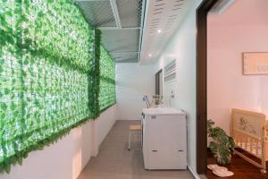 Cette chambre est dotée d'un mur vert et d'un réfrigérateur. dans l'établissement Minimal House Maximum Happiness, à Thung Maha Mek 73 autres photos