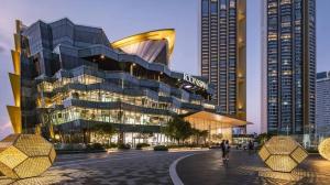 un grand bâtiment devant deux grands bâtiments dans l'établissement Minimal House Maximum Happiness, à Thung Maha Mek