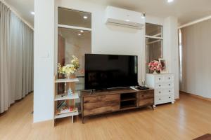 a living room with a flat screen tv on a entertainment center at บ้านเลม่อนริเวอร์ไซด์ in Nan