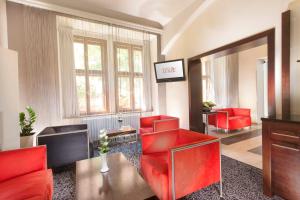 sala de estar con sillas rojas y espejo en Hotel Lunik, en Praga