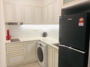eine Küche mit einem schwarzen Kühlschrank und einem Geschirrspüler in der Unterkunft Axon Residence Popular Suite Kl in Kuala Lumpur + 27 Fotos