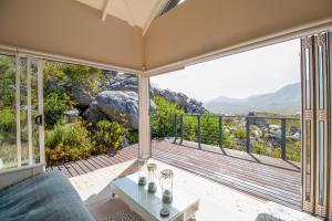 Una sala de estar con balcón con vista. en Tranquility Heights, en Pringle Bay