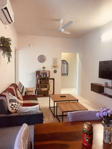 a living room with a couch and a table at Modern 2BHK Hideout in Benaulim in Benaulim