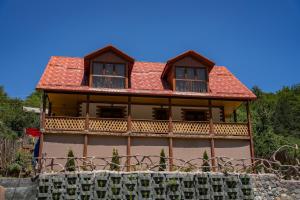 a large wooden house with a red roof at MaRu House in Dilijan