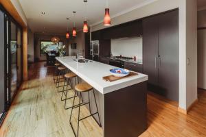 a kitchen with a large island with bar stools at Serenity Lodge Getaway - with river views in Egmont Village