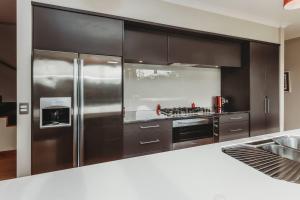 a kitchen with a stainless steel refrigerator and a stove at Serenity Lodge Getaway - with river views in Egmont Village