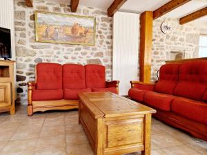 a living room with two red chairs and a table at Gîte de Saint-Gervais in Saint-Gervais