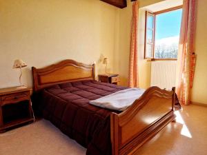 a bedroom with a wooden bed and a window at Gîte de Saint-Gervais in Saint-Gervais