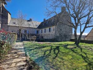an old stone house with a tree in the yard at Gîte de Saint-Gervais in Saint-Gervais
