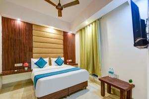 ein Schlafzimmer mit einem großen Bett und einem Fernseher in der Unterkunft Hotel Key Residency Near Delhi Airport kapashera in Neu-Delhi