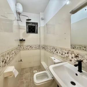 a white bathroom with a sink and a toilet at Zuri Cosy Stay Nyali, Furnished 2 bedroom in Mombasa +5 photos