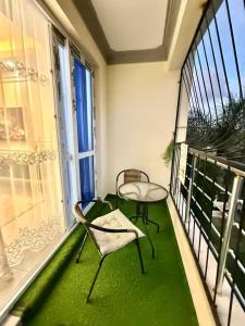 a balcony with a table and chairs on a green floor at Zuri Cosy Stay Nyali, Furnished 2 bedroom in Mombasa