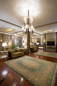 a living room with a chandelier and a large rug at Shelton's Rezidor Peshawar in Peshawar