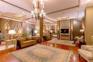 a living room filled with furniture and a chandelier at Shelton's Rezidor Peshawar in Peshawar