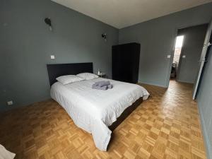 une chambre avec un grand lit avec des draps blancs dans l'établissement Rétro Lomme, à Lille