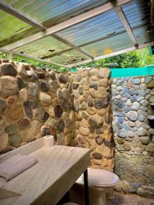 uma casa de banho com uma parede de pedra e um WC em Dome #1 em Rivas