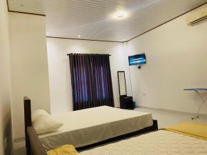 Una habitación con dos camas y un televisor en la pared. en Lodge in Resolute, en Dambulla 56 fotos más