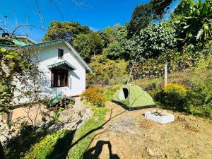 una tienda verde en un patio junto a una casa en Hotel CCR ! Ravangla, en Ravangla