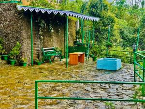 un jardín con banco, mesa y valla en Hotel CCR ! Ravangla, en Ravangla 2 fotos más