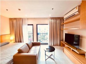 un salon avec un canapé et une télévision à écran plat dans l'établissement Noble Remix Thonglor - Direct BTS Access - Super Fast Wi-Fi, à Bangkok