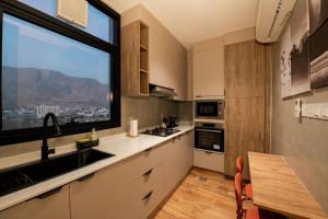 a kitchen with a sink and a large window at شقة فندقية جميلة و مخصصة للايجار لشخصين في بوشر - مسقط - القرم in Jāl