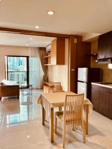 une cuisine avec une table, des chaises et un réfrigérateur dans l'établissement Noble Remix Thonglor - Direct BTS Access - Super Fast Wi-Fi, à Bangkok