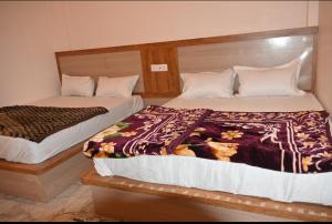 two beds sitting next to each other in a room at Malwa resort in Chitrakoot