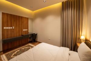 a hotel room with a bed and a desk at شقة فندقية جميلة و مخصصة للايجار لشخصين في بوشر - مسقط - القرم in Jāl