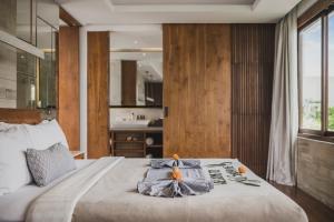 a bedroom with a bed with a towel on it at Sana Vie Villa Seminyak by Ini Vie Hospitality in Seminyak