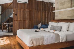 a bedroom with a large bed and a blue couch at Sana Vie Villa Seminyak by Ini Vie Hospitality in Seminyak