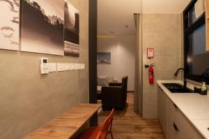 a kitchen with a counter and a table and a chair at شقة فندقية جميلة و مخصصة للايجار لشخصين في بوشر - مسقط - القرم in Jāl