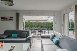 una sala de estar con un sofá y una mesa en Villa piscine entre lac et océan, en Cazaux