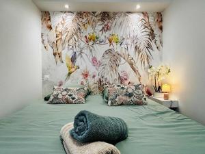 Un dormitorio con una cama verde con una pared floral. en la bulle d'Edward gare jardin centre, en Angulema