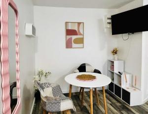 Una habitación con una mesa y sillas y un televisor. en la bulle d'Edward gare jardin centre, en Angulema