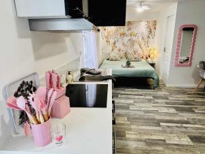 a kitchen with a sink and a room with a bed at la bulle d'Edward gare jardin centre in Angoulême