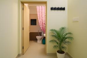 a bathroom with a toilet and a potted plant at Casa61 Homestay in Bengaluru +24 photos