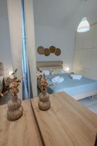 twee vazen op een tafel in een kamer met een bed bij Musses villas in Limín Khersonísou