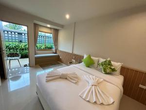 ein Schlafzimmer mit einem Bett, auf dem zwei Kleider liegen in der Unterkunft Transit Samui Resort in Koh Samui 