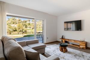 ein Wohnzimmer mit Couch und großem Fenster in der Unterkunft Serração House - Gerês in Rio Caldo